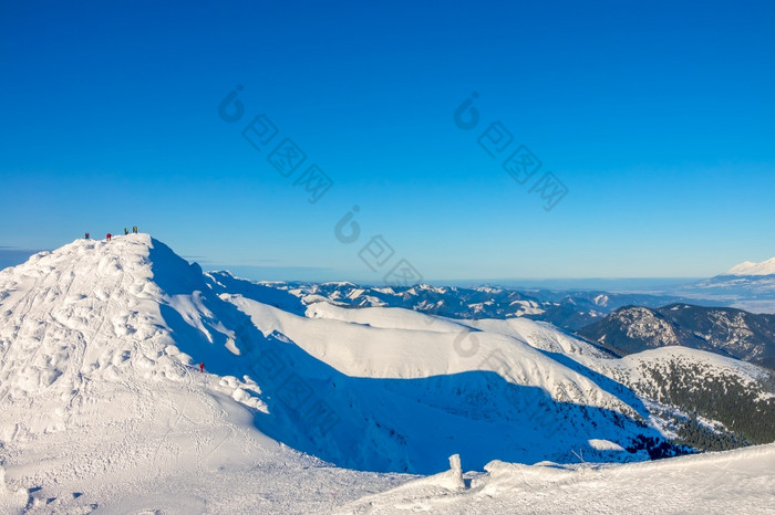阳光明媚的天气和万里无云的蓝色的天空很多雪的山峰和山坡上的冬天山雪山峰和蓝色的天空