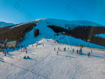 斯洛伐克冬<strong>天明</strong>亮阳光明媚的<strong>一</strong>天滑雪山坡上的树木繁茂的山蓝色的天空和太阳照明亮空中视图滑雪者的冬天滑雪坡阳光明媚的<strong>一</strong>天空中视图