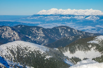 冬天斯洛伐克低基雪山峰阳光明媚的天气和山谷森林白雪覆盖的山峰和阳光明媚的天气