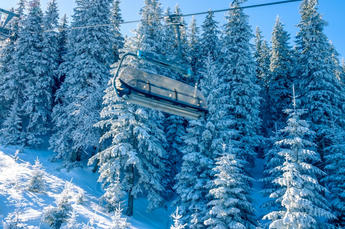 阳光明媚的早....的冬天森林空小屋滑雪椅子电梯很多雪的树分支机构空小屋滑雪电梯和早....雪森林