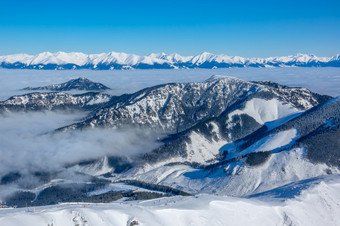 的上衣<strong>冬</strong>天<strong>山</strong>和雾的<strong>山</strong>谷滑<strong>雪</strong>度假胜地阳光明媚的天气和蓝色的天空空中视图<strong>雪</strong>封顶<strong>山</strong>峰和雾的<strong>山</strong>谷空中视图