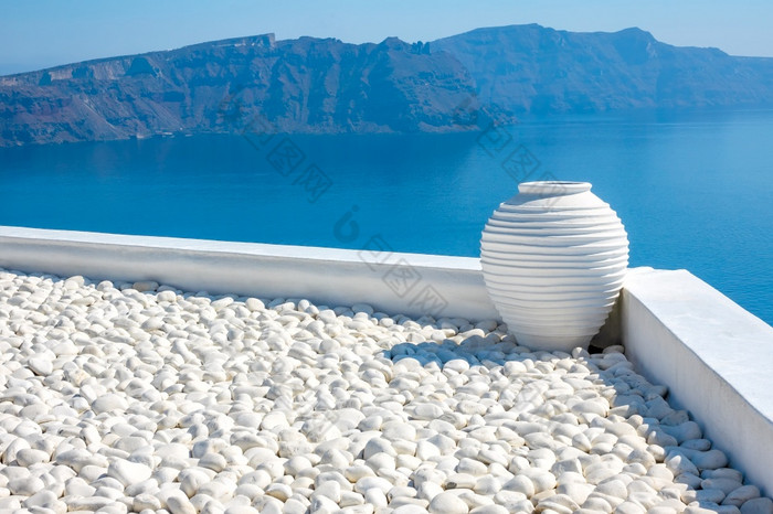 希腊阳光明媚的一天圣托里尼岛白色鹅卵石和白色石头花瓶海景与岩石岛屿白色石头花瓶和阳光明媚的岛屿