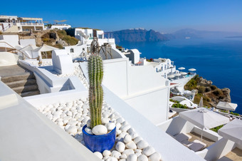 希腊锡拉圣托里尼岛白色房子的aio多山的海岸阳光明媚的一天和装饰仙人掌白色鹅卵石白色房子圣托里尼岛和装饰仙人掌