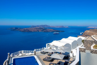 希腊圣托里尼岛锡拉岛酒店的高银行aio池和太阳便鞋为放松阳光明媚的天气海景酒店池高银行和海景