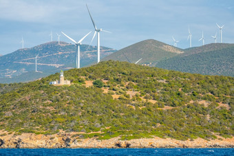 希腊丘陵海岸的海湾哥林多阳光明媚的天气老灯塔建筑和许多风农场灯塔和风农场丘陵海岸