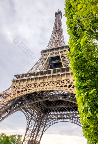法国巴黎多云的夏天一天底视图的埃菲尔铁塔塔和绿色树底视图的埃菲尔铁塔塔多云的天气