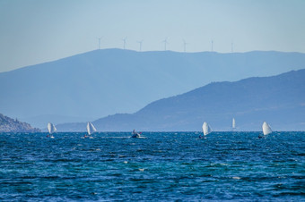 夏天湾阳光明媚的一天多山的海岸几个小体育游艇和教练电动机船几个体育游艇培训