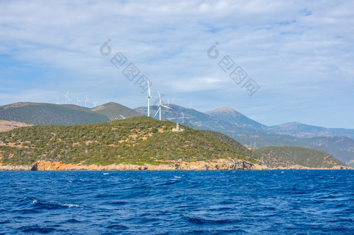 希腊丘陵海岸的海湾哥林多阳光明媚的一天老灯塔建筑和许多风农场风农场丘陵海岸和灯塔