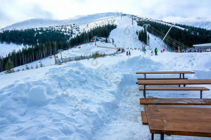 冬天斯洛伐克滑雪度假胜地明亮阴空木长椅和表附近滑雪坡休息的地方的滑雪坡