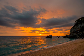 小海滩之间的的悬崖的希腊海岸的地中海海色彩斑斓的日出在平静水色彩斑斓的海日出小海滩