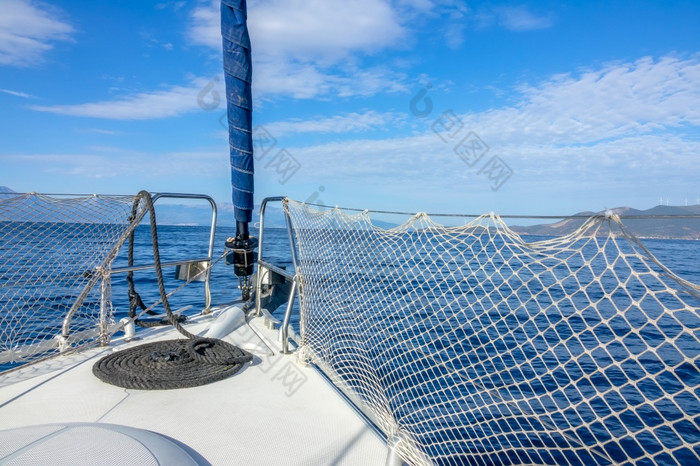 航行游艇的平静海游艇弓绳子和卷云云的蓝色的天空弓航行游艇和卷云云