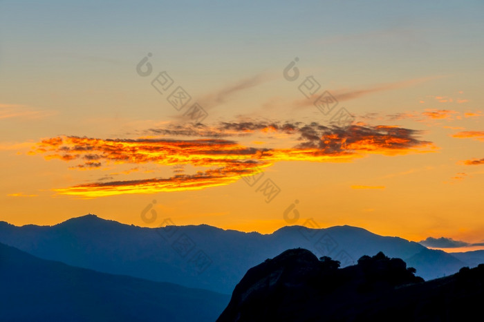 希腊轮廓的山山峰金天空与云后日落金天际天空在的山山峰