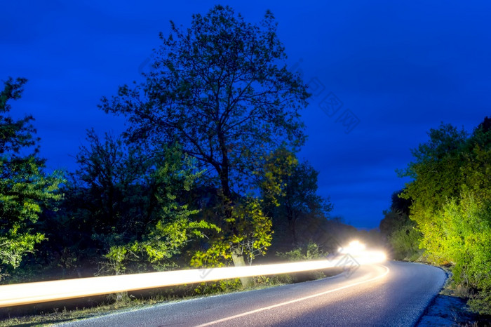 头灯照亮空路夏天晚上森林长绕组头灯小径晚上路和头灯小径