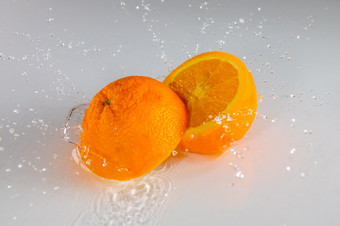 白<strong>色</strong>表格<strong>和</strong>薄层水两个半成熟的橙<strong>色和</strong>很多溅两个半橙<strong>色和</strong>很多水喷雾
