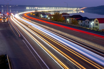 郊区高速公路的晚些时候晚上痕迹从头灯和尾灯重交通和灯的桥晚上车交通与小径郊区高速公路