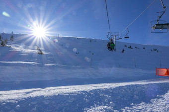 斯洛伐克冬天滑雪度假胜地明亮明亮的太阳的蓝色的天空在的山腰和的行的椅子电梯明亮的太阳滑雪度假胜地和椅子电梯
