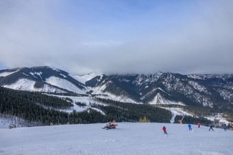 斯洛伐克冬天滑雪度假胜地明亮滑雪者和救援雪地的滑雪坡低云隐藏了山山峰滑雪者和救援雪地对的背景山山峰隐藏的低云