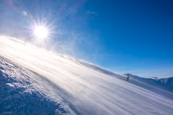 陡峭的滑雪坡和明亮的太阳暴雪的表面滑雪游乐设施下来孤独的滑雪阳光明媚的坡和暴雪