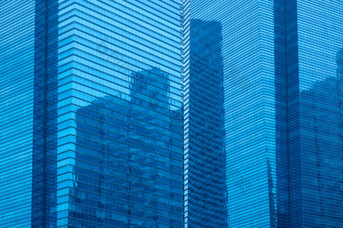多层摩天大楼与玻璃外墙和反射另一个摩天大楼摩天大楼背景