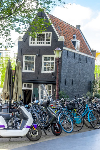 荷兰阳光明媚的春天一天阿姆斯特丹自行车停车前面倾斜的典型的荷兰房子倾斜的房子和自行车阿姆斯特丹
