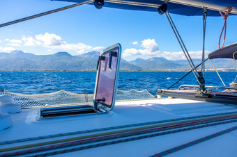 夏天阳光明媚的一天上航行游艇索具和桅杆视图的丘陵海岸视图从的一边航行游艇丘陵海岸