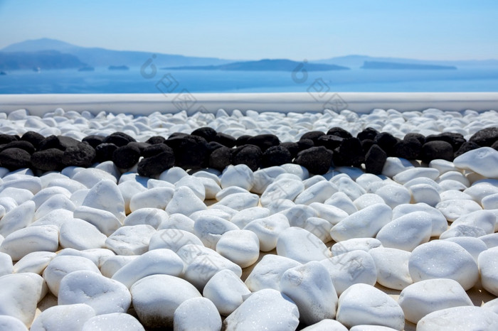 希腊圣托里尼岛锡拉岛白色和黑色的石头的阳台与海视图白色和黑色的石头的阳台与海视图