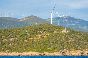 希腊丘陵海岸的海湾哥林多阳光明媚的天气许多风农场和老灯塔建筑风农场和灯塔丘陵海岸