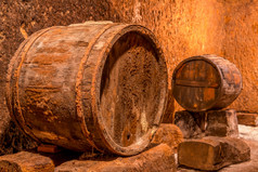 老橡木桶与生锈的篮球深酒地窖与变形墙老酒地窖和桶