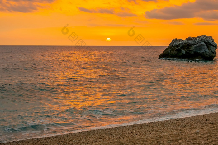 孤独的岩石的海附近的桑迪海滩色彩斑斓的日出在的平静水域的希腊地中海海岸孤独的岩石的海黎明和带桑迪海滩
