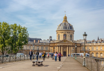 法国夏天一天巴黎人的人行桥的艺术和马萨林图书馆的背景巴黎艺术桥和马萨林图书馆