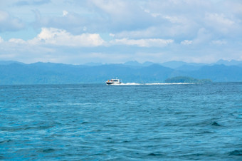 印尼多云的天空和电动机游艇移动快沿着热带海岸电动机游艇帆快附近热带岛