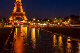 法国巴黎游客和汽车附近的埃菲尔<strong>铁塔</strong>塔与晚上照明反射的禁用喷泉的特罗卡迪罗广场花园埃菲尔<strong>铁塔</strong>塔和禁用特罗卡迪罗广场喷泉的晚些时候晚上