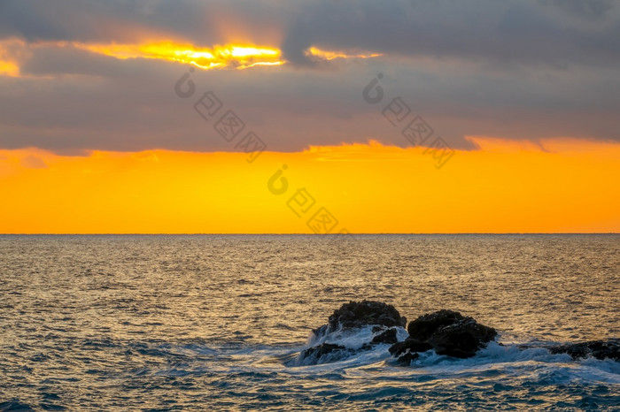 令人惊异的日落颜色多云的天空沿海石头的平静海令人惊异的海日落颜色和沿海岩石