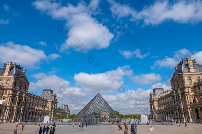 法国夏天阳光明媚的天气巴黎的著名的院子里的罗浮宫博物馆和的玻璃金字塔许多游客云游客的金字塔的罗浮宫和云