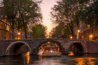 荷兰粉红色的日落的<strong>阿姆斯特丹</strong>运河快乐船下的石头桥粉红色的日落的<strong>阿姆斯特丹</strong>运河和船下的桥