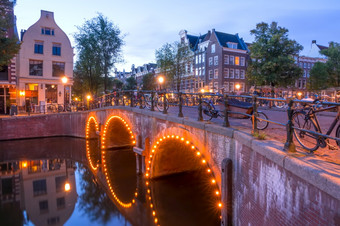 荷兰石头桥与三个拱门的阿姆斯特丹运河很多停自行车几分钟之前黎明黎明前的阿姆斯特丹桥