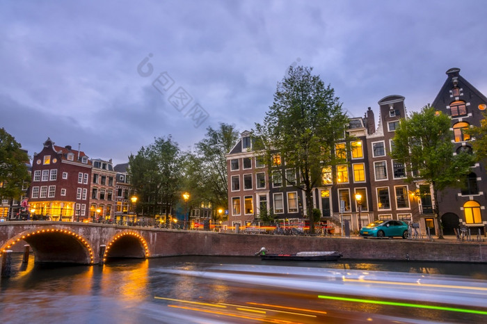 荷兰晚上的阿姆斯特丹运河老石头桥和典型的房子的路堤交通的水和街道晚上灯的阿姆斯特丹运河