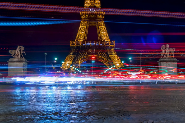 法国晚上的脚的埃菲尔铁塔塔重交通叶子很多长曝光灯许多灯晚上交通对的背景的埃菲尔铁塔塔