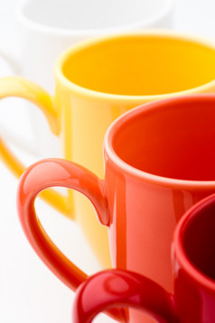 明亮的杯子的角度来看行明亮的色彩斑斓的杯子红色的橙色黄色的而且白色白色背景