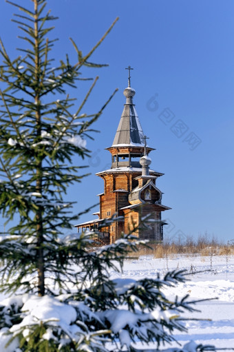 小木教堂冬天清晰的天空背景绿色冷杉树前景焦点教堂