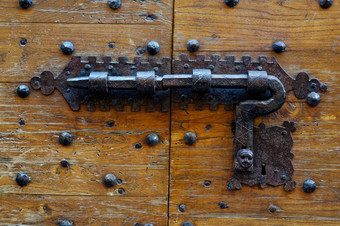 背景和纹理古老的木通过关闭与传统的伪造的金属锁古老的通过与伪造的金属锁