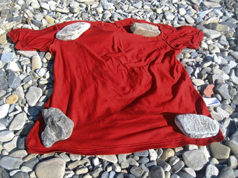 红色的t恤躺的海岸下四个石头