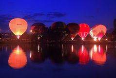 热空气baloons飞行的晚上天空附近的湖