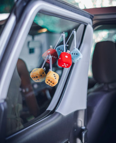 可爱的毛茸茸的玩具挂的车通过窗口蹒跚学步的的回来的车概念