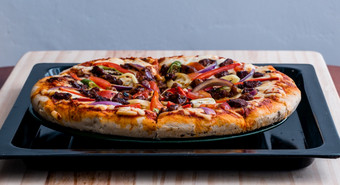 热披萨是采取出从的<strong>烤箱</strong>自制的和美味的快食物切片而的<strong>烤箱</strong>托盘和准备好了吃鸡奶酪和色彩斑斓的贝尔胡椒配料