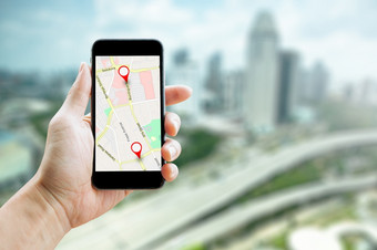 男人。手持有智能手机与全球定位系统(gps)地图路线目的地网络连接位置街地图与全球定位系统(gps)图标导航和红色的图标位置在线导航概念