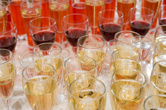许多高脚杯子与香槟红色的酒而且水果饮料自助餐表格浅景深