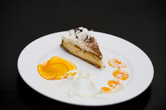 一块海绵蛋糕与白色而且黑暗巧克力服务与橙色片而且糖浆