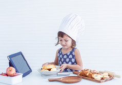 高加索人小女孩学习在线准备和使面包店首页