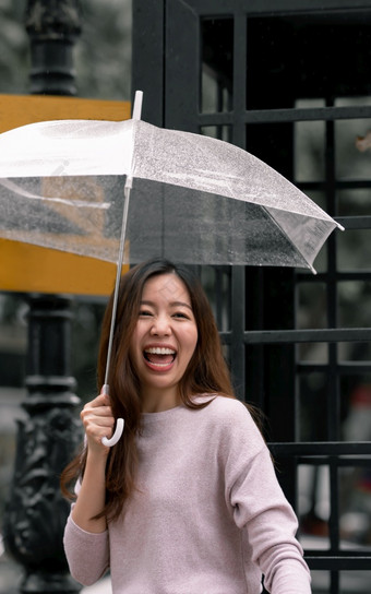 亚洲美丽的女人持有伞下雨季节而站城市生命系统概念